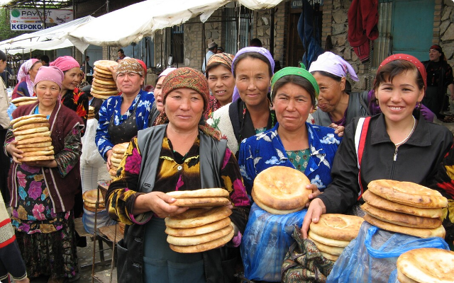 Uzbek women buying bread at a market.